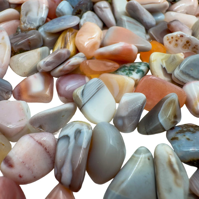 Pink agate polished chips in hand showing size reference, 0.25 to 0.50 inch pieces