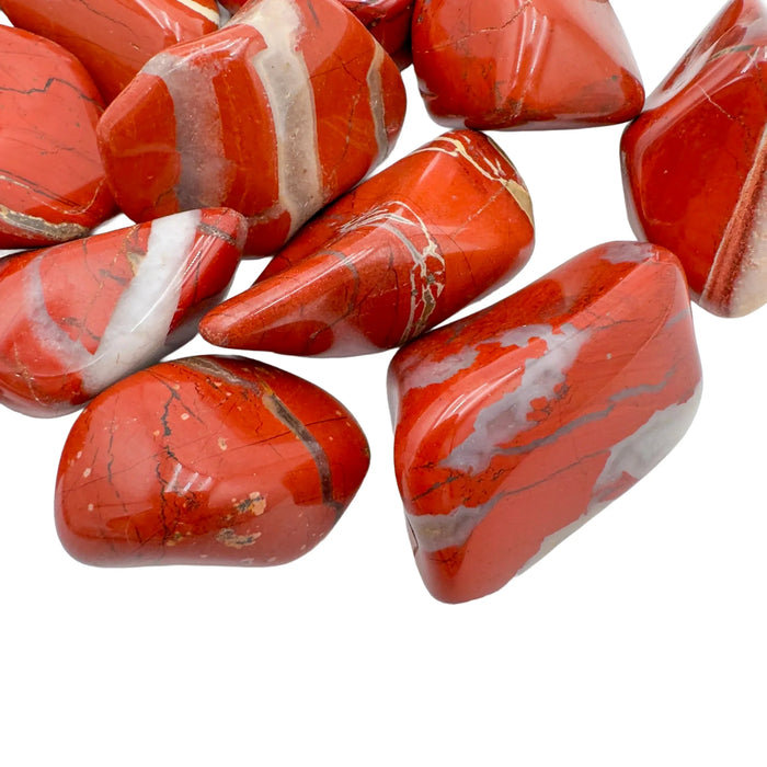 Edge-on view of Grade AA Red Jasper tumbled stone, hand-selected from Northern Cape, South Africa, showing earthy tone.