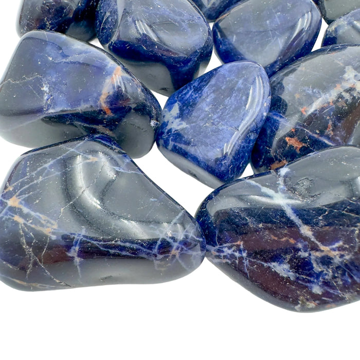 Lateral view of Sodalite tumbled stone, showing natural sheen.