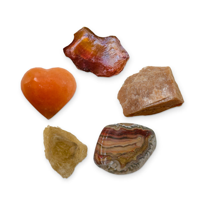 Sacral Chakra Crystal Kit: orange calcite heart, carnelian, peach moonstone, crazy lace agate and natural citrine, shown together on white