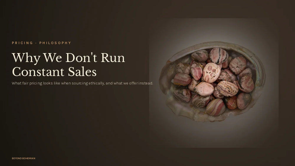 Tumbled rhodochrosite on dark moody backdrop for why we don't run constant sales article
