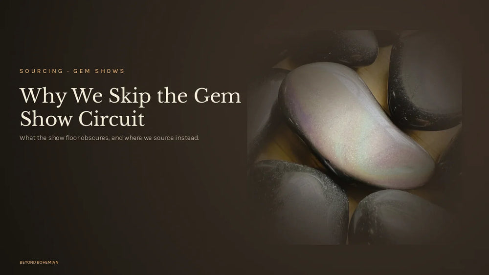 Rainbow obsidian stone on dark moody backdrop for why we don't source at gem shows article