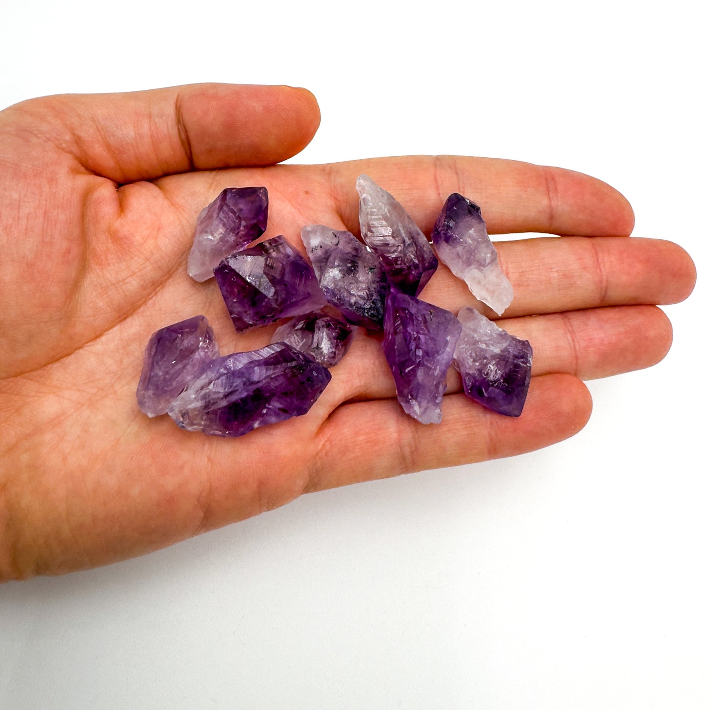Hand-scale view of Amethyst raw crystal, with character of the piece on display.