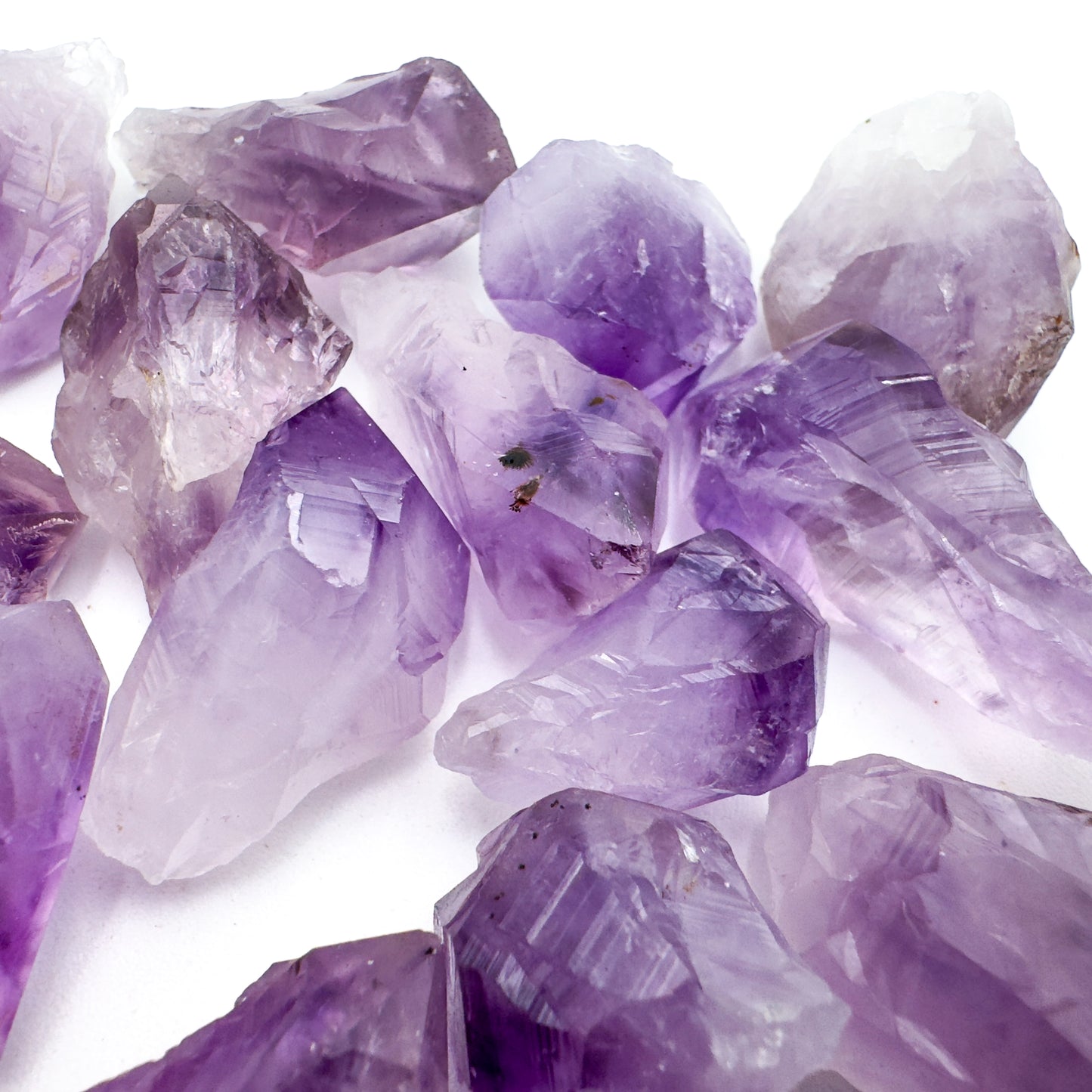 Held in hand, a single Amethyst raw point hand-selected from Rio Grande do Sul, Brazil.