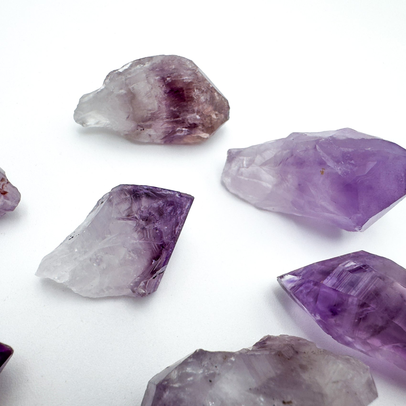 Size comparison with a Amethyst raw point held against natural backdrop.