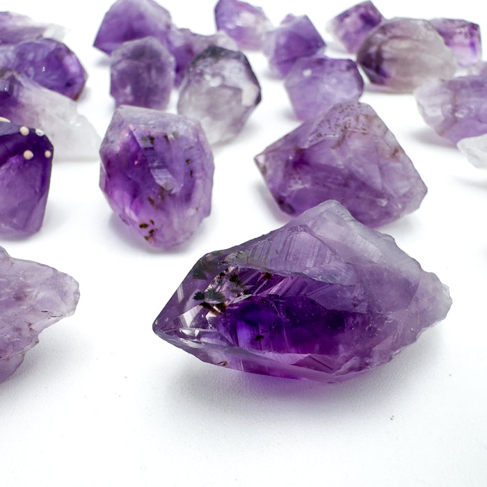 Macro view of Amethyst raw point, drawn on for Stress Relief and Sleep, showing natural banding.
