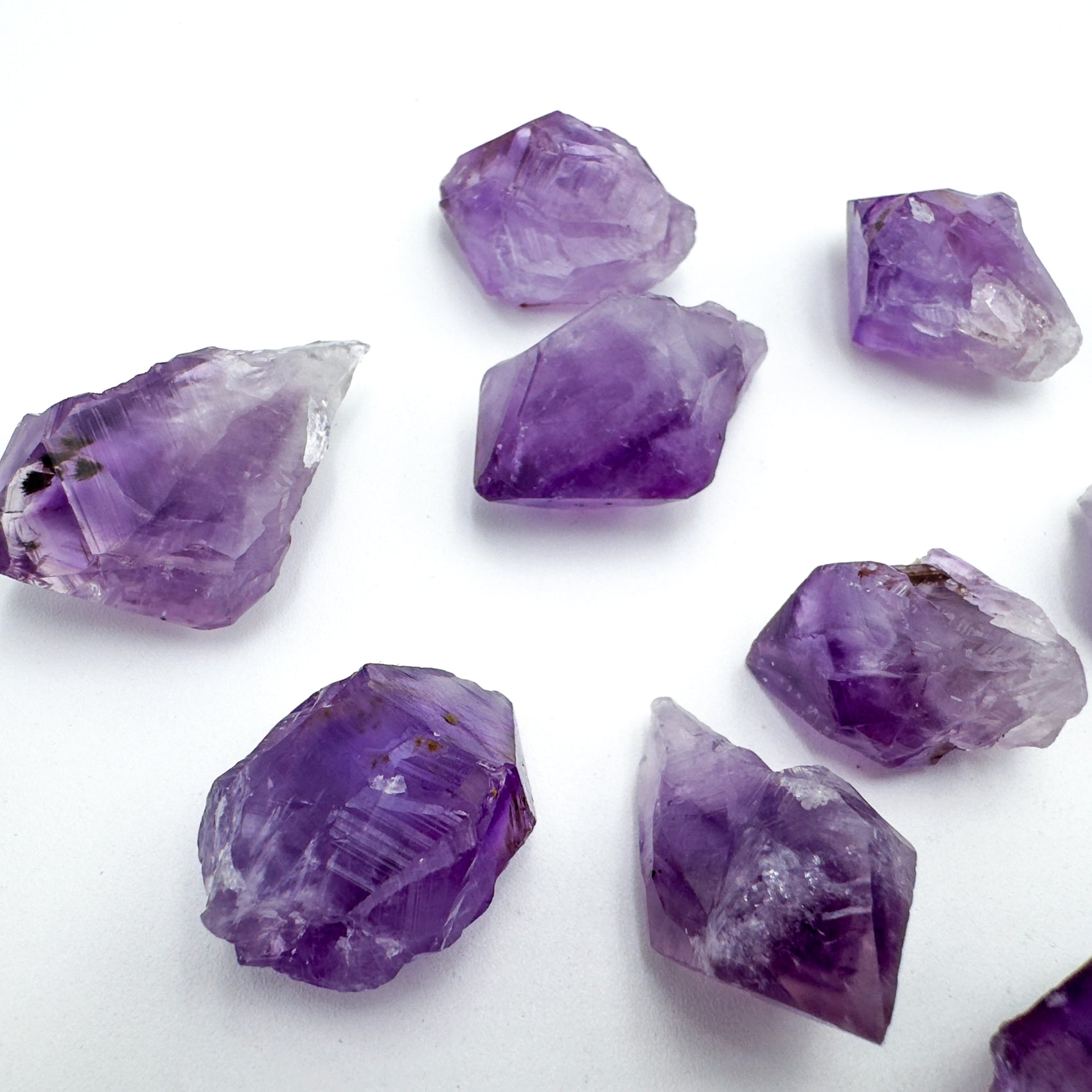 Size comparison with a Amethyst raw point held against natural backdrop, Brazil-sourced.