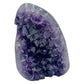AAA grade amethyst geode from Uruguay, angled three-quarter view, a grey-green shell with an olive mineral seam on one face, specimen 15.
