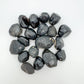 Sideways view of Apache Tear raw stone, showing subtle veining, sourced from Arizona, United States.