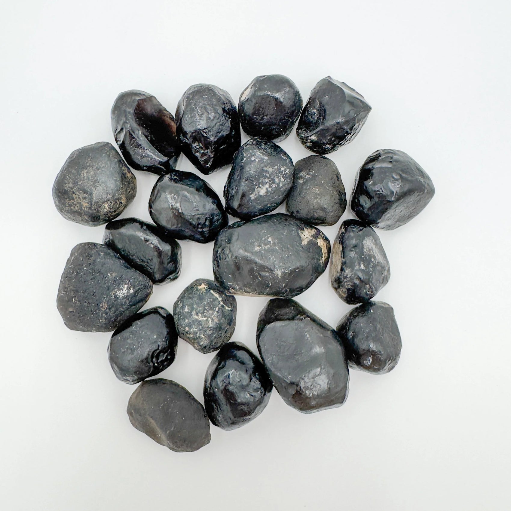 Sideways view of Apache Tear raw stone, showing subtle veining, sourced from Arizona, United States.