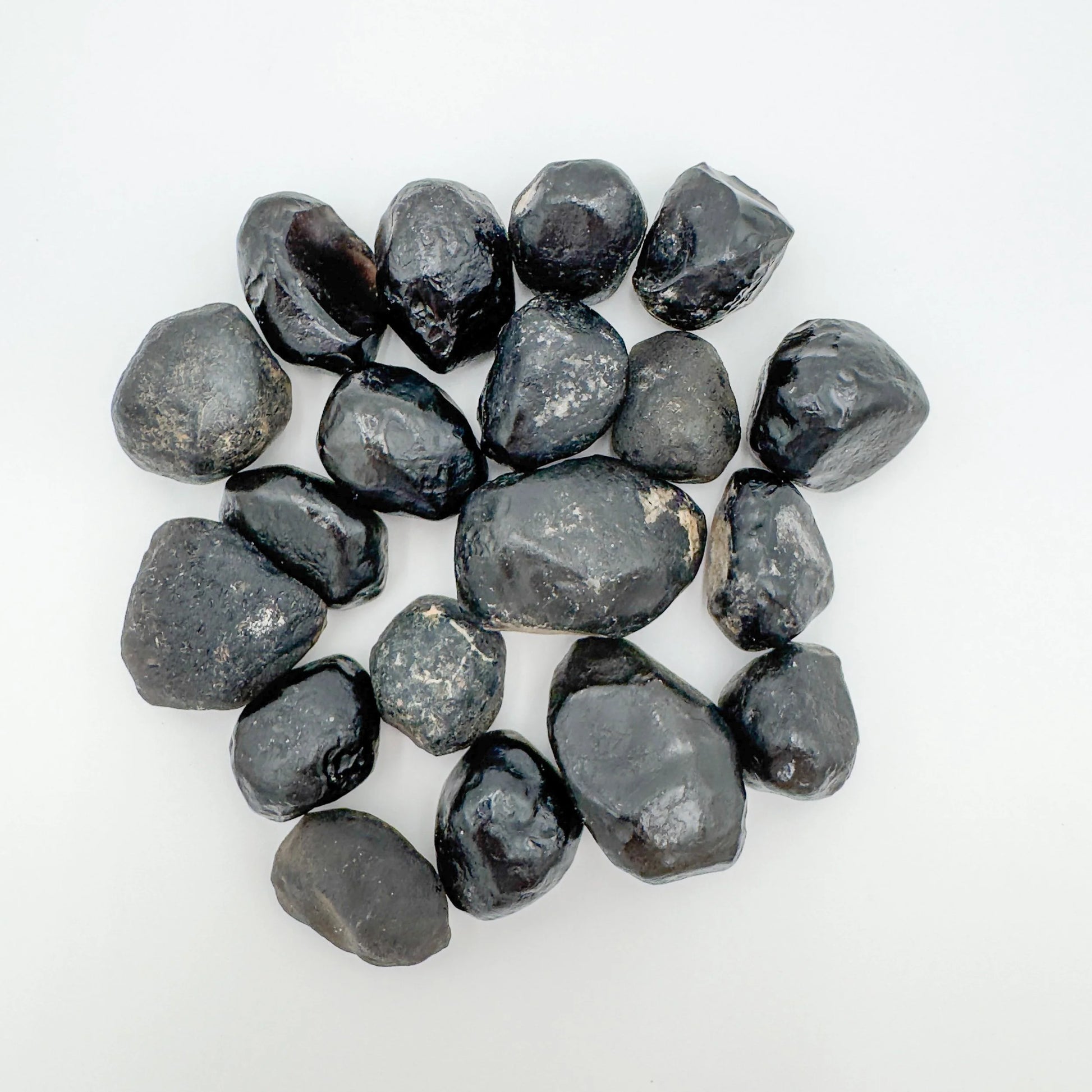 Sideways view of Apache Tear raw stone, showing subtle veining, sourced from Arizona, United States.