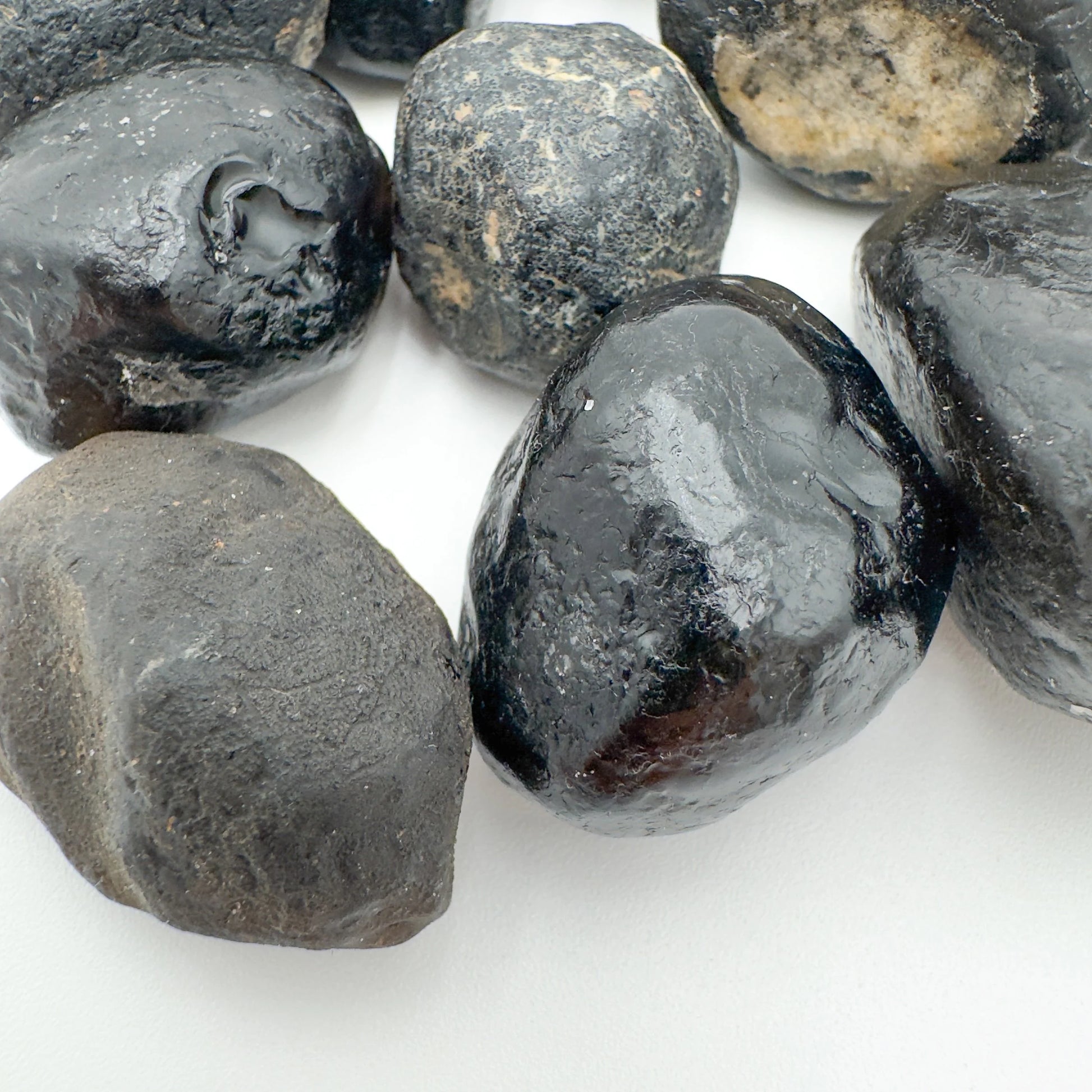 Top-side view of Apache Tear raw stone, showing natural color depth, hand-selected from Arizona, United States.