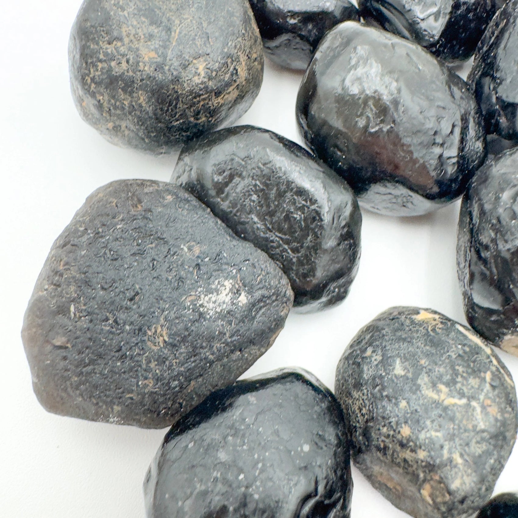 Underside view of Grade A Apache Tear raw stone, linked to Grounding, from Arizona, United States.