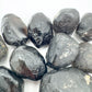 Hand-held view of a single Apache Tear raw stone United States-sourced, sourced from Arizona, United States.