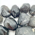 Hand-held view of a single Apache Tear raw stone United States-sourced, sourced from Arizona, United States.