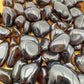Underside view of Apache Tear tumbled stone, associated with Grounding and Protection.