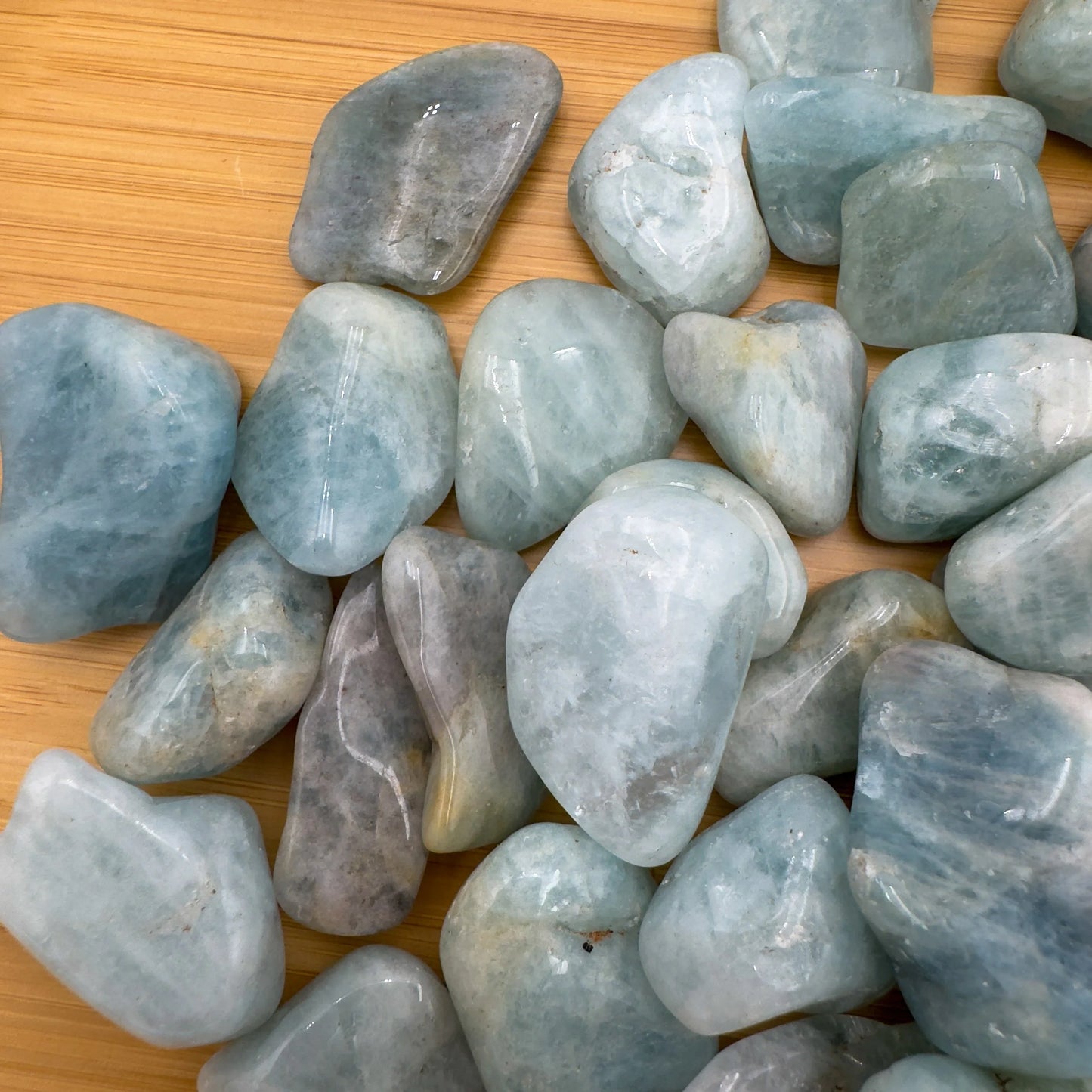 Top view of Grade A Aquamarine tumbled stone, often paired with practices around Stress Relief.