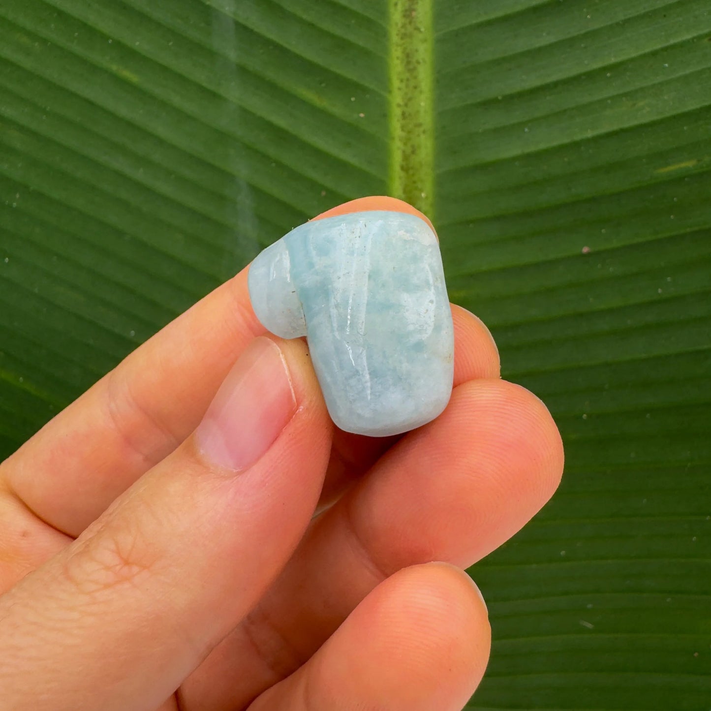 Detail shot of Grade A Aquamarine tumbled stone under natural light