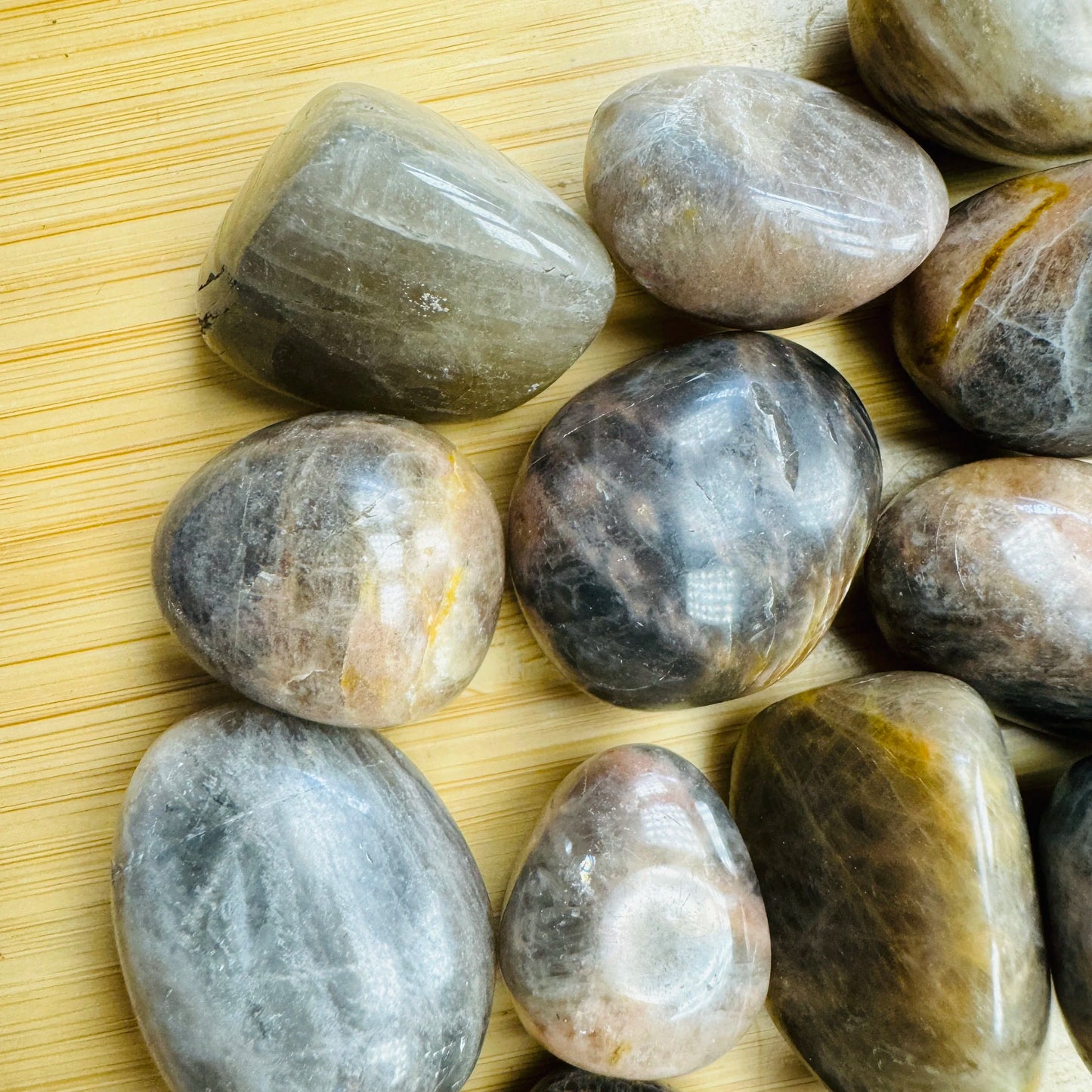 Top-down shot of Black Moonstone tumbled stone, sourced from Madagascar.