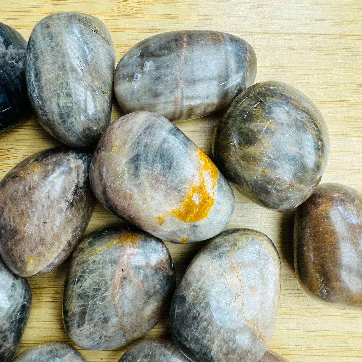 Magnified detail of Grade AA Black Moonstone tumbled stone, showing subtle veining.