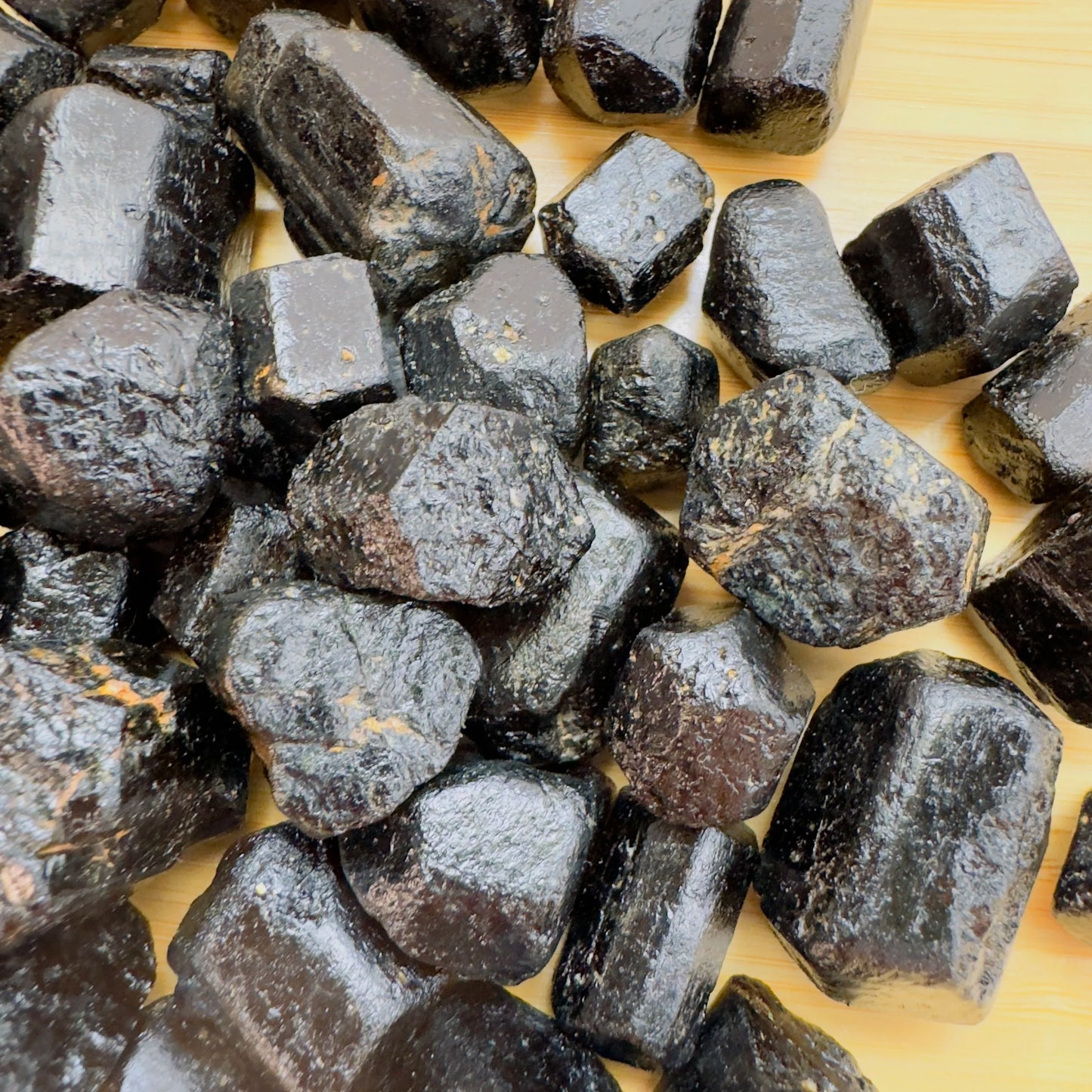 Top-down shot of Grade A Black Tourmaline raw stone, showing characteristic finish, drawn on for Protection.