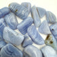 Three-quarter view of Blue Lace Agate tumbled stone, from ǁkaras Region, Namibia, with hand-sized presence.