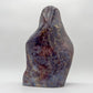 Natural light view of a Blue Rose Quartz freeform held against natural backdrop, sourced from Madagascar.