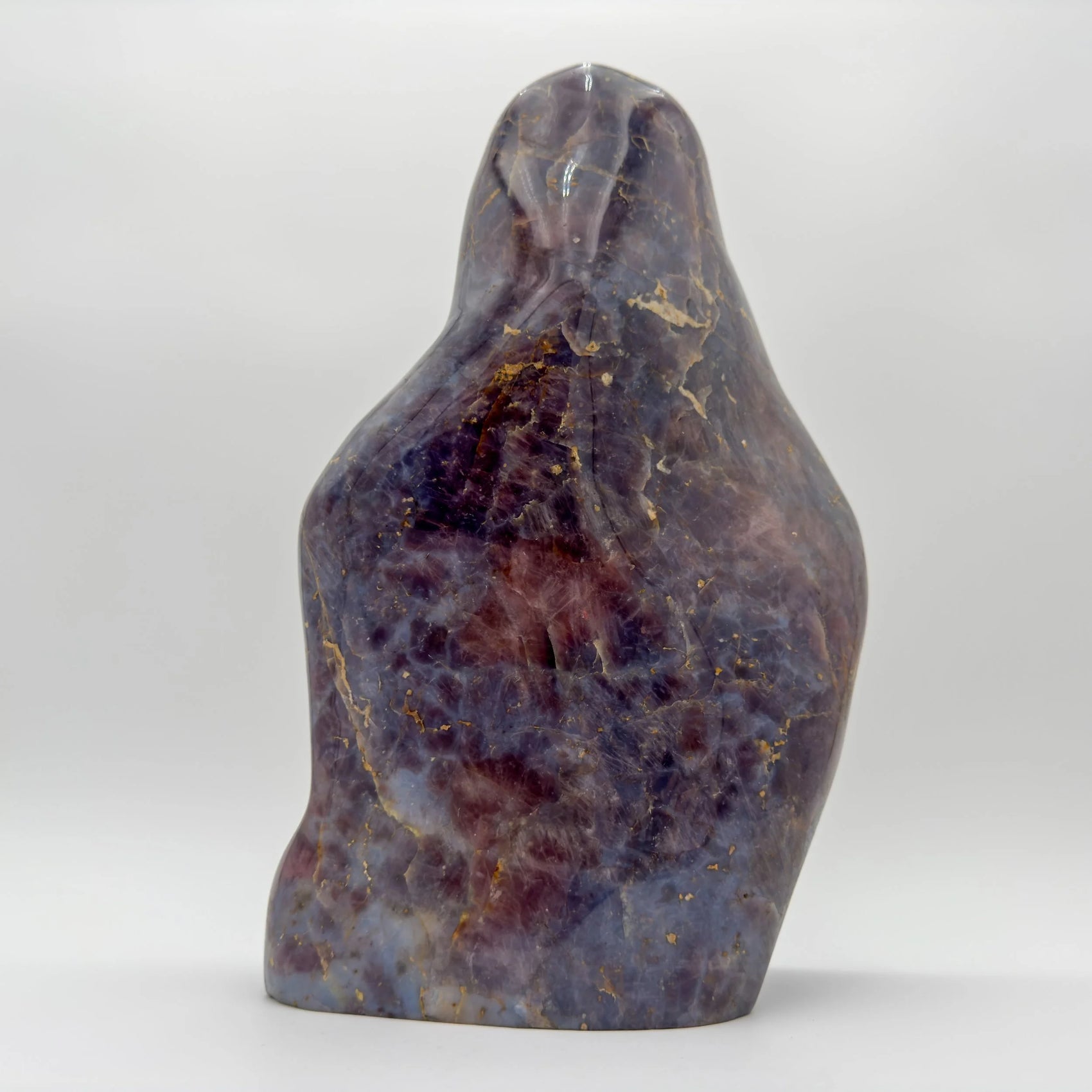 Natural light view of a Blue Rose Quartz freeform held against natural backdrop, sourced from Madagascar.