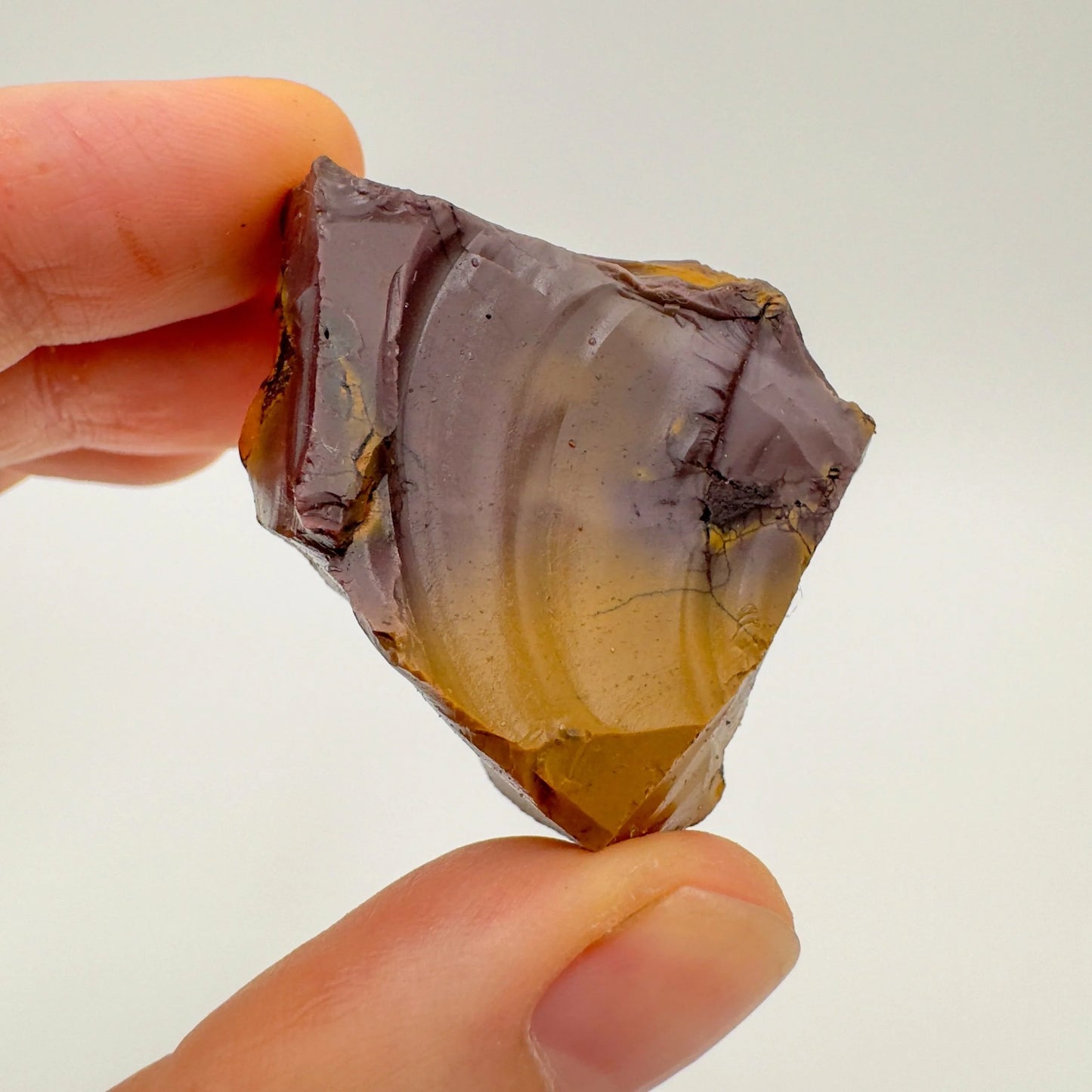 Hand-scale shot of a single Mookaite raw stone hand-selected from Western Australia, Australia.