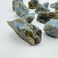 Side profile of Grade AA Labradorite raw stone, showing natural patina.