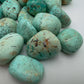 Edge-on view of Chrysocolla tumbled stone, showing subtle veining.