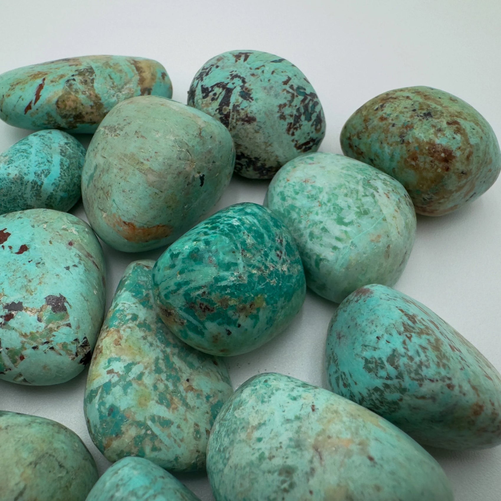 Rear view of Grade A Chrysocolla tumbled stone, sourced from Arequipa, Peru.