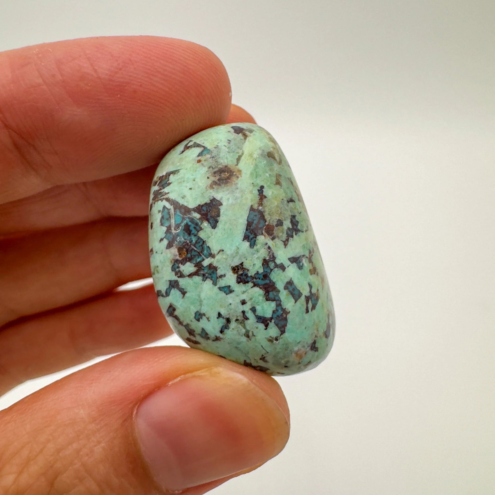 Back view of Grade A Chrysocolla tumbled stone showing natural surface