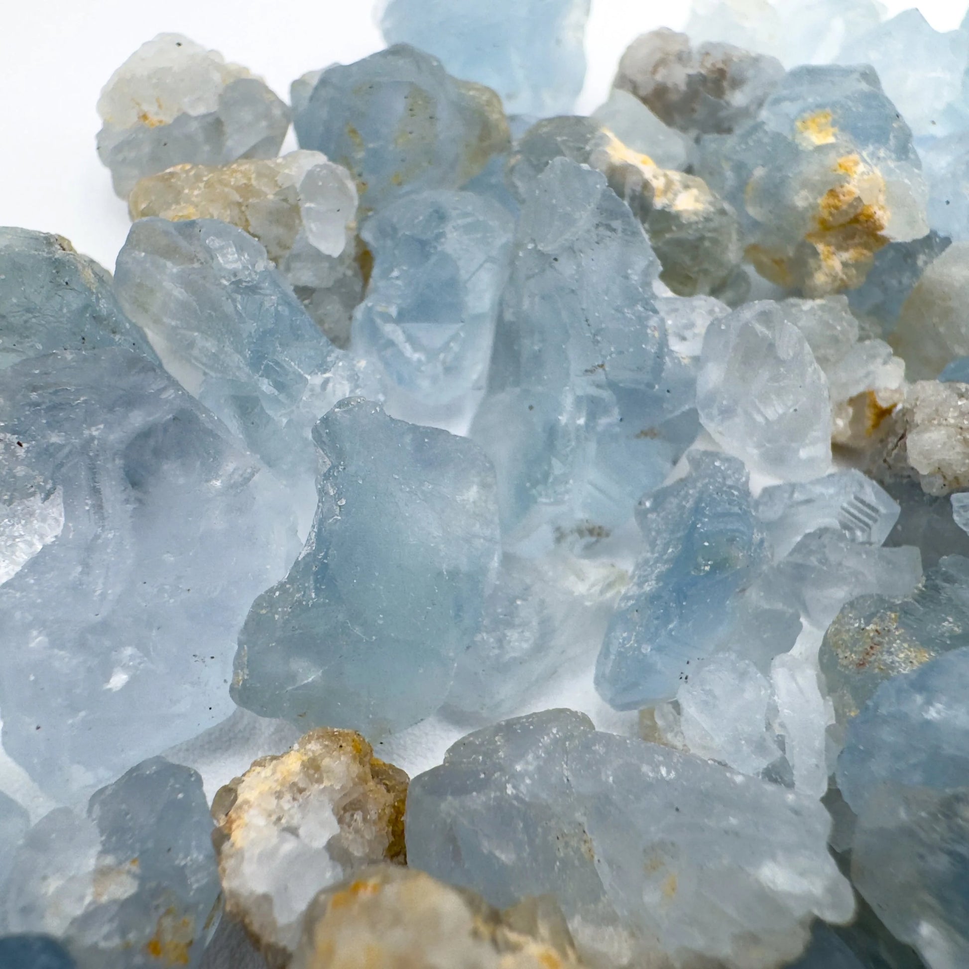 Held in palm of a Celestite raw crystal, from Sakoany, Madagascar, traditionally used for Stress Relief, with depth visible across the surface.