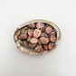 Detail of Rhodochrosite tumbled stone, showing earthy tone.