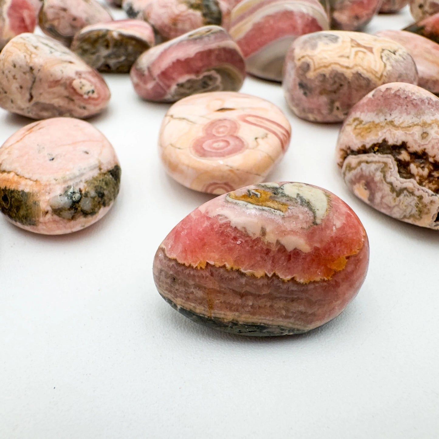 Side angle of Rhodochrosite tumbled stone, sourced from Argentina.
