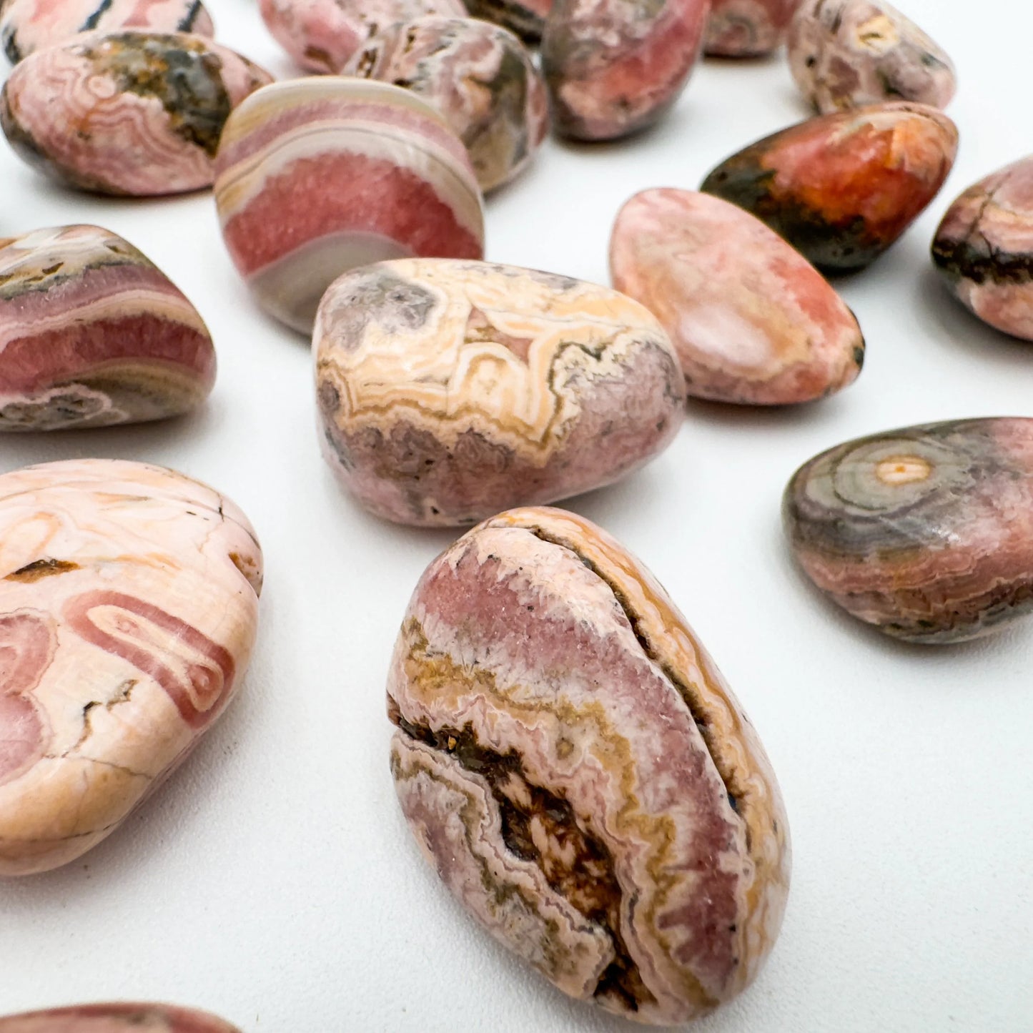 Top-down shot of Rhodochrosite tumbled stone, for Emotional Healing, sourced from Argentina.