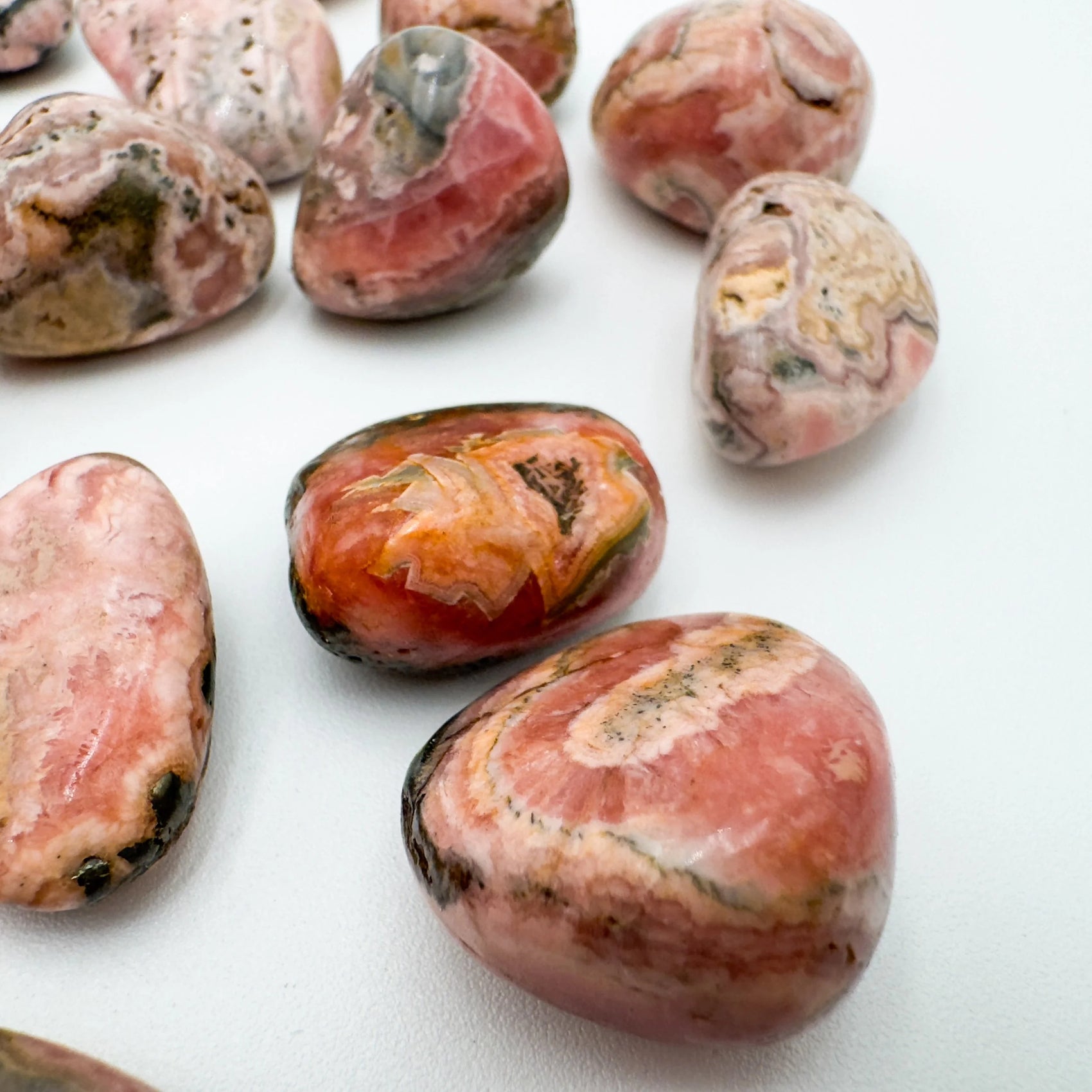 Underside view of Grade A Rhodochrosite tumbled stone, often paired with practices around Emotional Healing and Love.