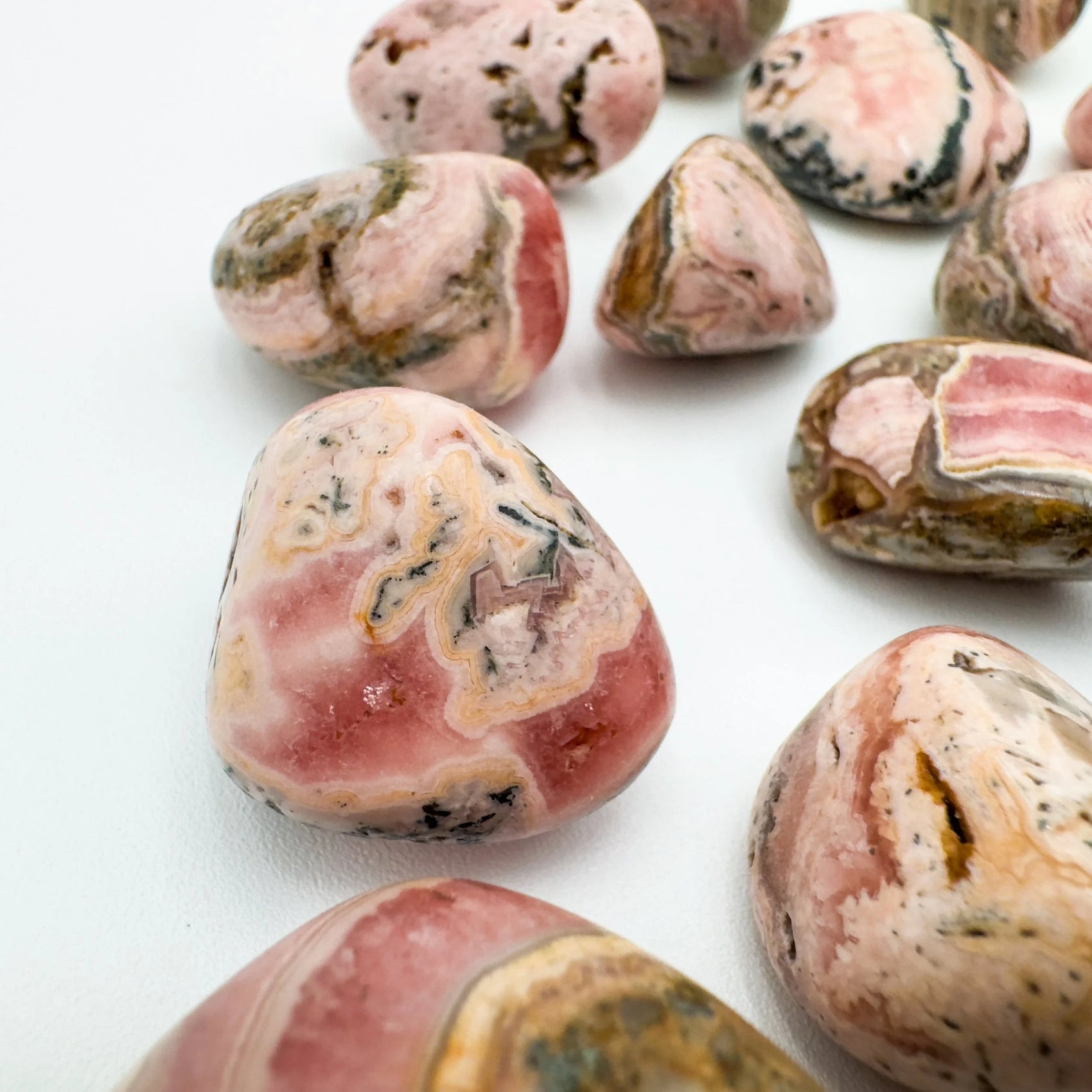 Daylight detail of Rhodochrosite tumbled stone, from Catamarca Province, Argentina, with surface texture in view.