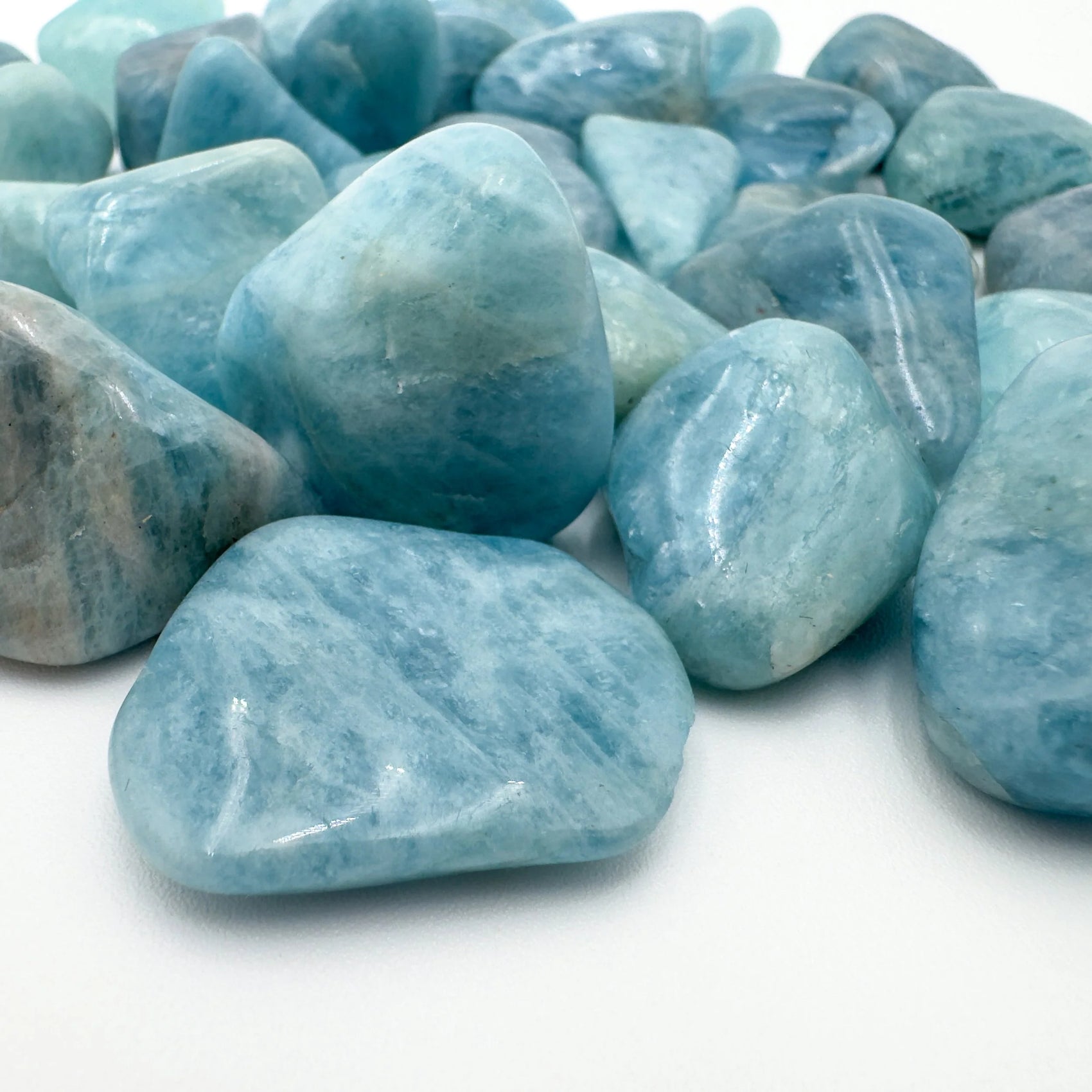 Reverse side of Aquamarine tumbled stone, showing characteristic color, from Brazil.