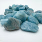 Side profile of Aquamarine tumbled stone, showing translucent edges.