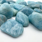 Scale reference of a Aquamarine tumbled stone often paired with practices around Stress Relief.