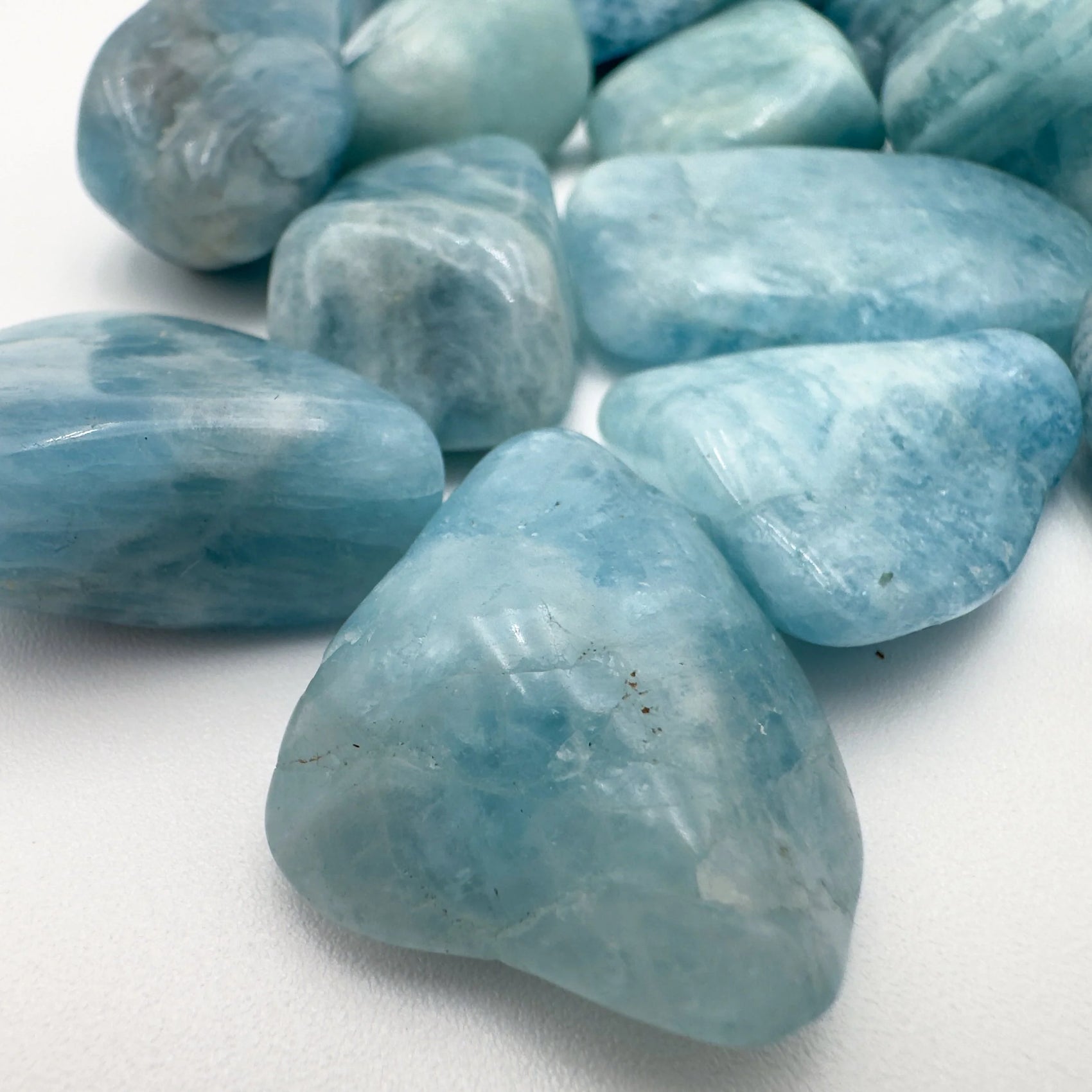 Styled with natural light Aquamarine tumbled stone, with depth visible across the surface.