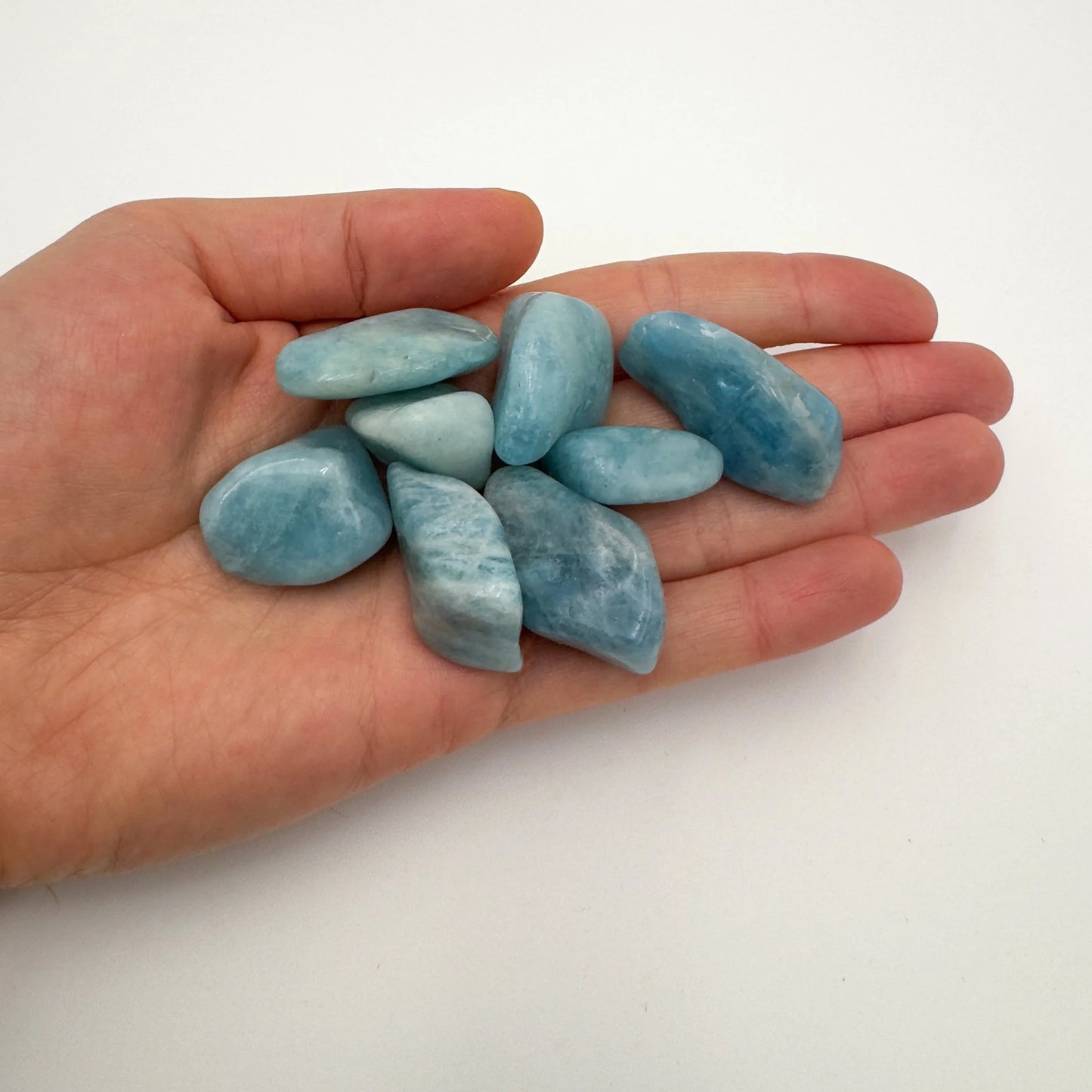 Detail shot of Grade AAA Aquamarine tumbled stone under natural light