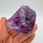 Grade aa amethyst raw held in hand for size reference