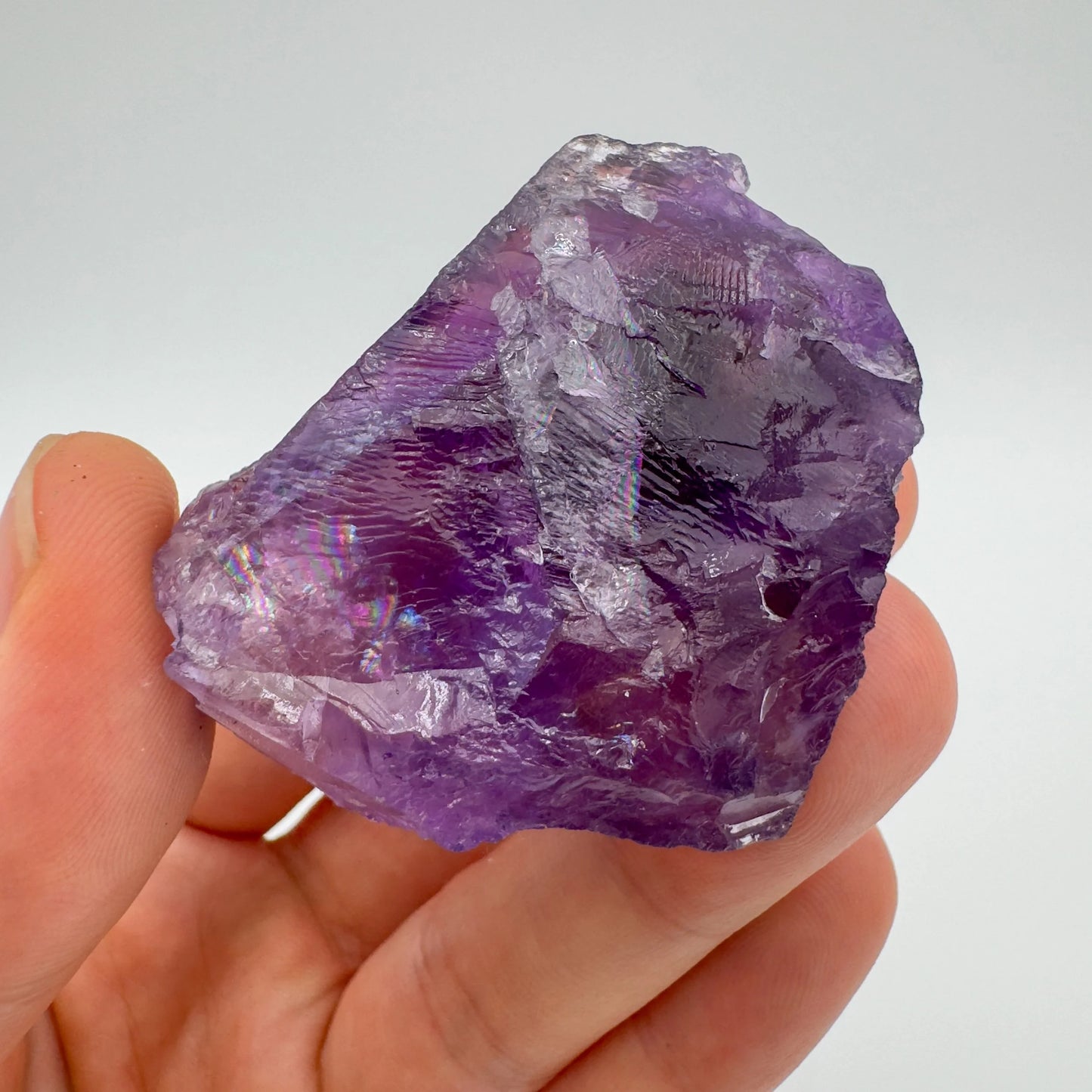 Grade aa amethyst raw held in hand for size reference
