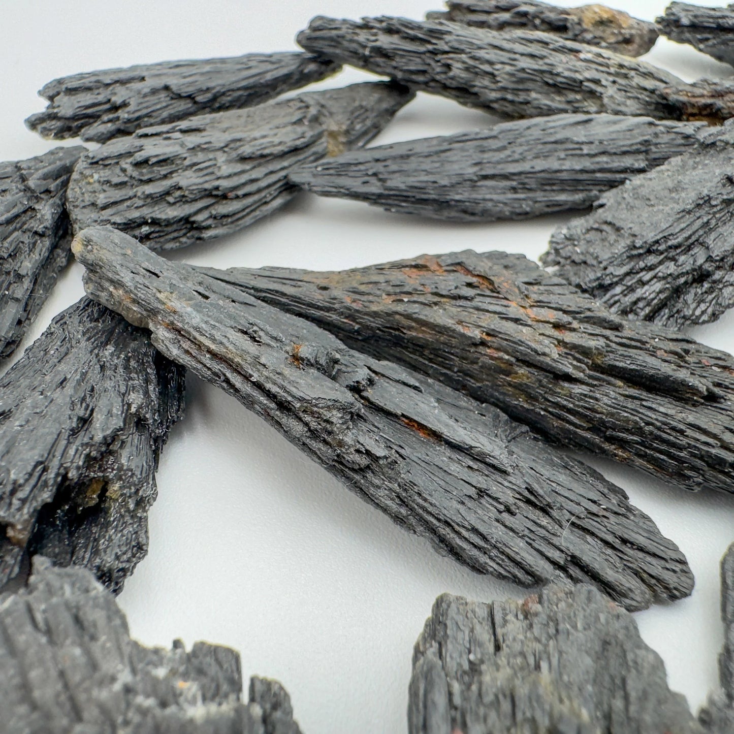 In-hand view of one Black Kyanite raw stone for scale, sourced from Brazil.