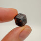 Holding a Fuchsite raw crystal, with natural details visible.