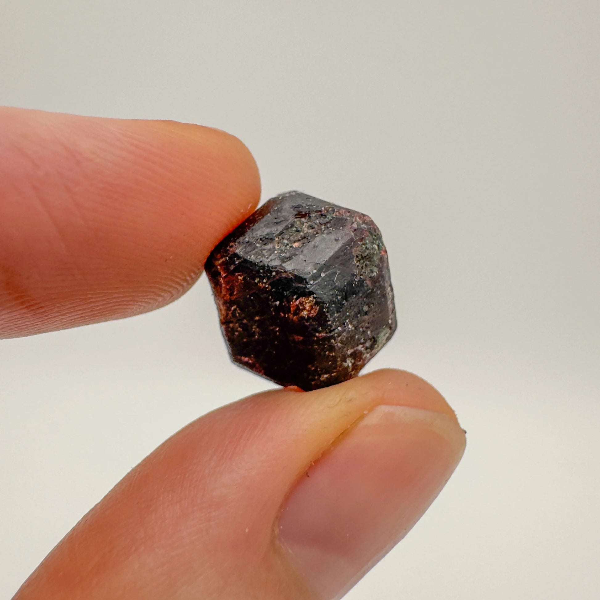 Holding a Fuchsite raw crystal, with natural details visible.