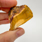Hand-scale view of Mookaite stone, associated with Adventure, shown alongside the hand for scale.